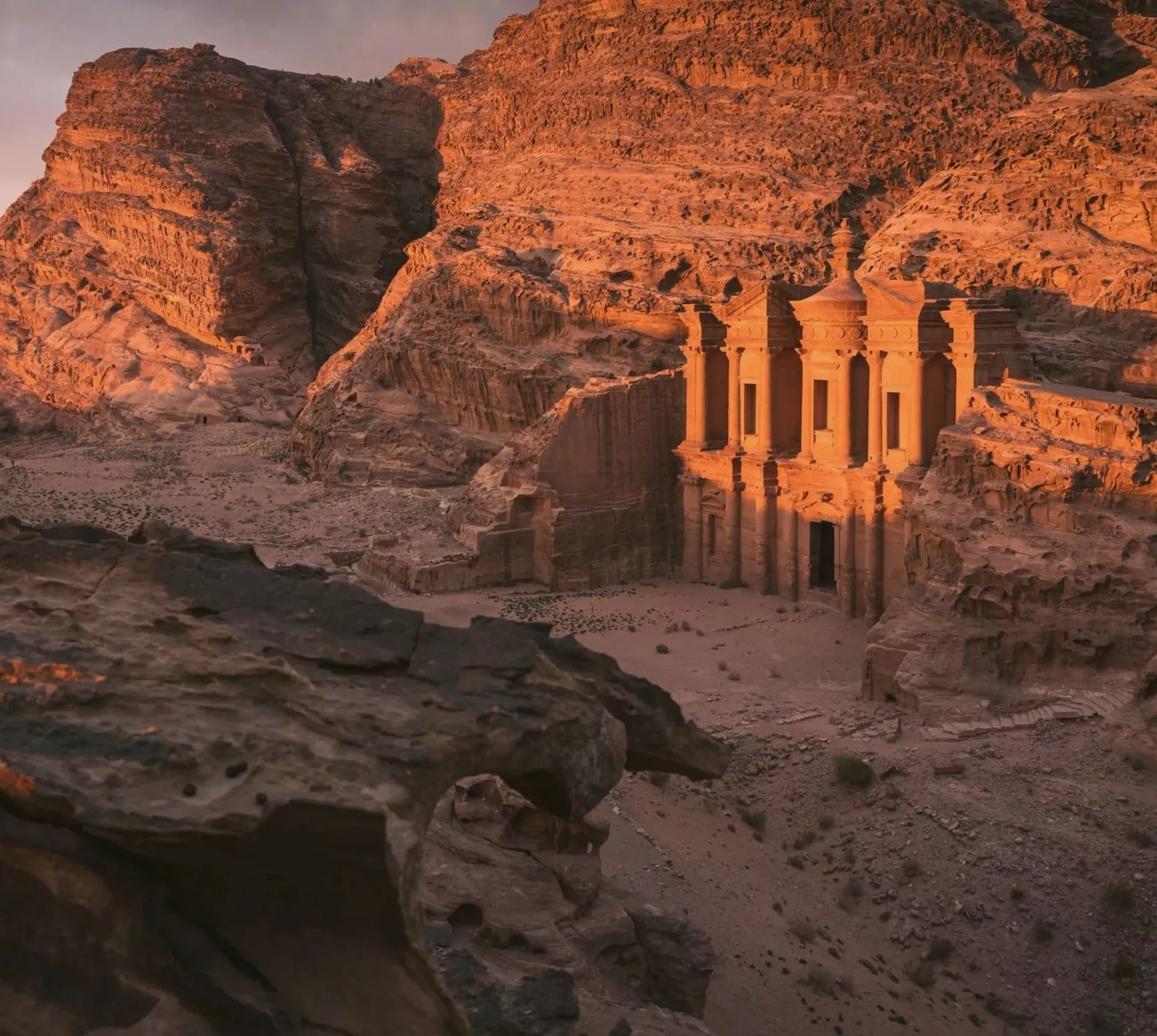 The Monastery in Petra glows at sunset, surrounded by towering sandstone cliffs on the Contiki Best of Egypt & Jordan Tour
