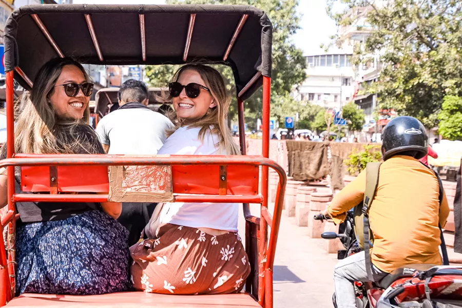 Two Girls Riding On Rickshaw Through Delhi Streets