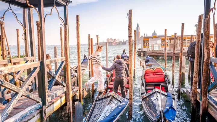 A traveller being helped onto a gondola in Venice, Italy