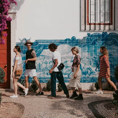 Travellers walking past traditional blue azulejo tiles in Lisbon, Portugal - Contiki Spain, Portugal & Morocco Uncovered Tour