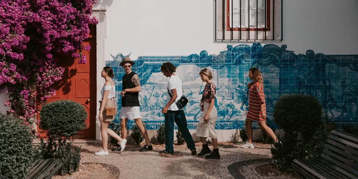 Travellers walking past traditional blue azulejo tiles in Lisbon, Portugal - Contiki Spain, Portugal & Morocco Uncovered Tour