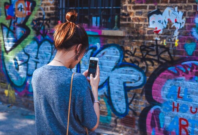 Woman Taking Photo Of Graffiti with Phone