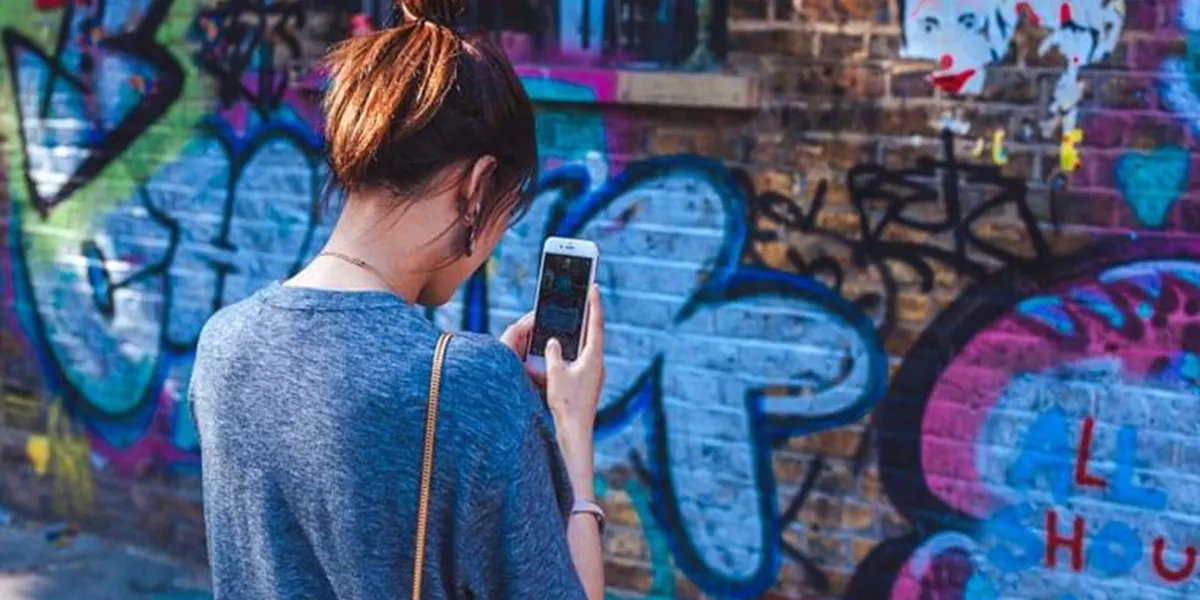 Woman Taking Photo Of Graffiti with Phone