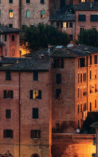 Historic Tuscan town at sunset, featuring terracotta rooftops and traditional Italian architecture on the Contikii Tuscan Escape Tour
