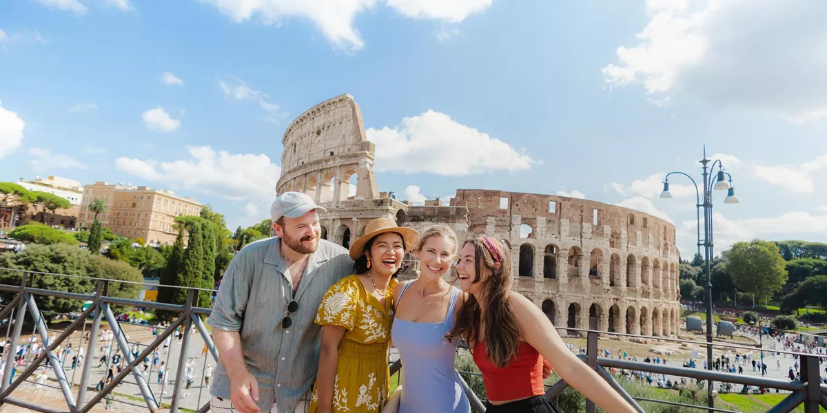 Four Friends Smiling Rome Landmark Building At The Back