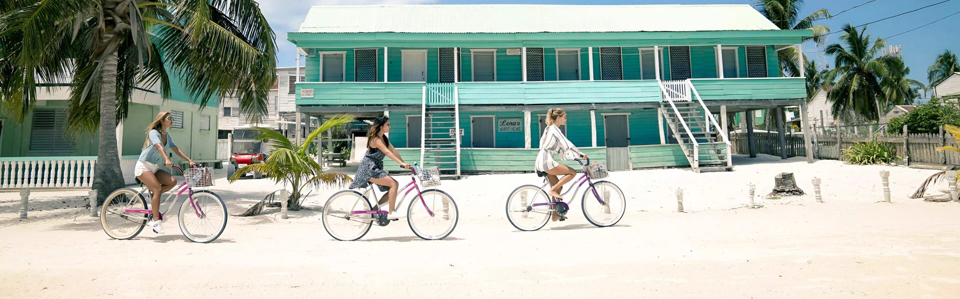 Three young women cycling next to home.