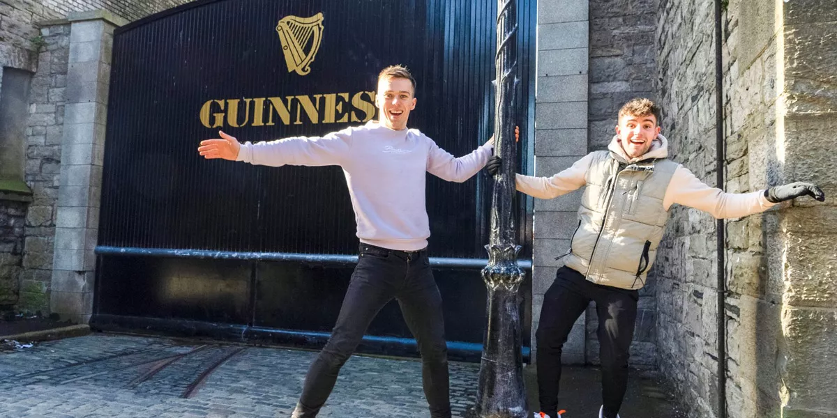 Two Friends Smiling Guinness Brewery Gate At The Back