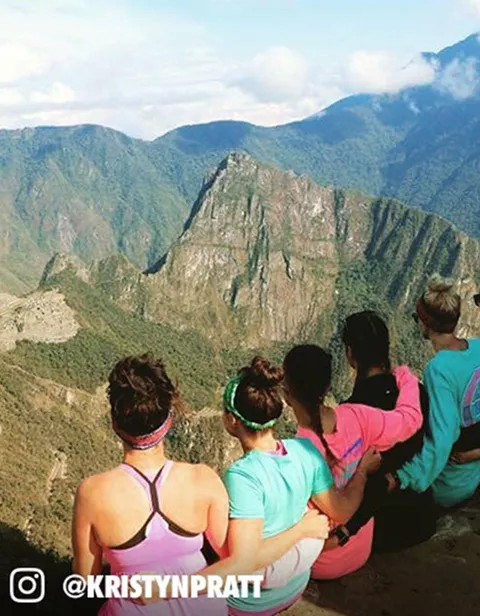 People posing for a photo above a mountain valley