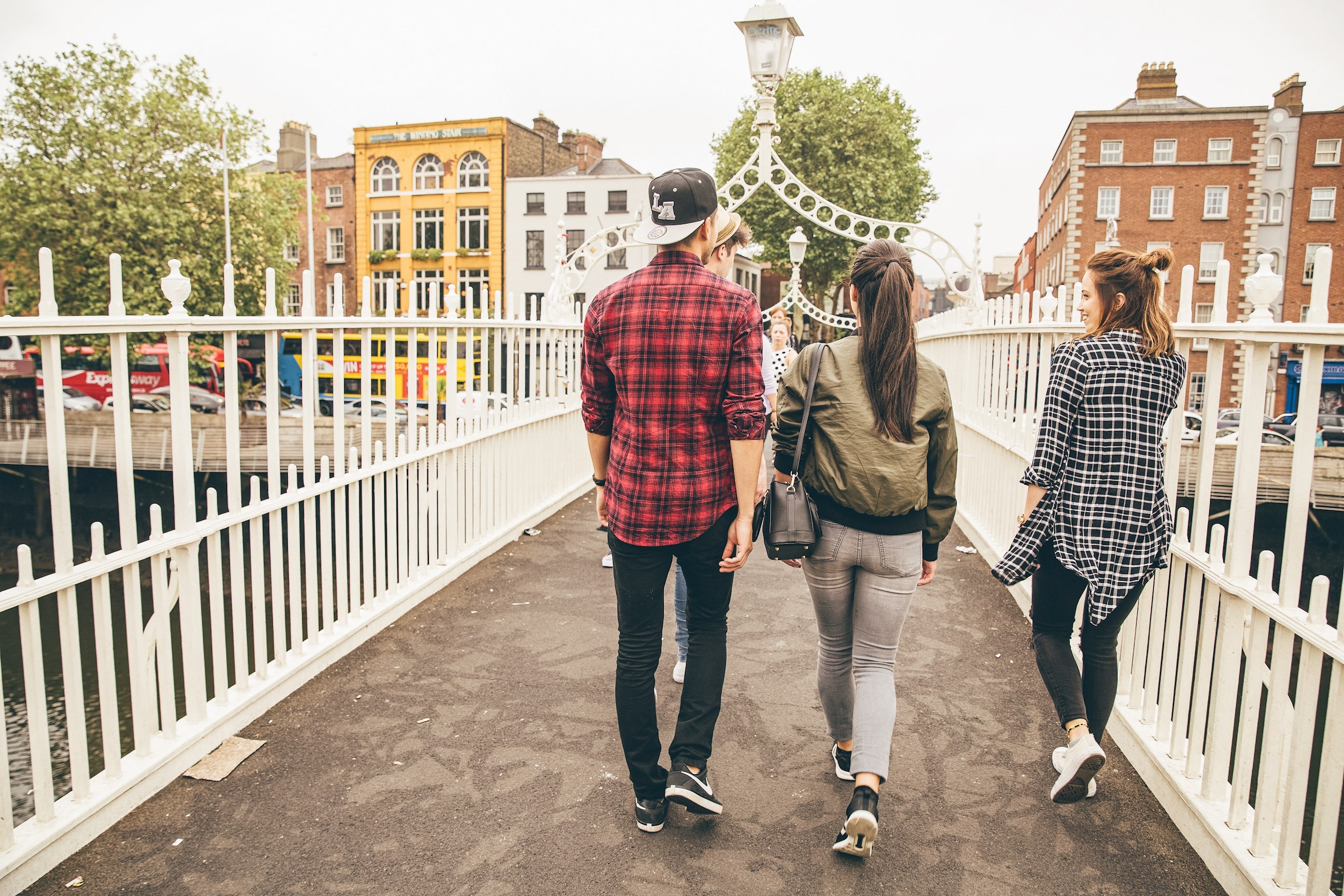 Travellers walking over Ha'penny bridge in Dublin, Ireland