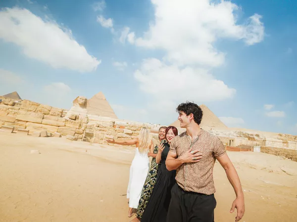 Smiling Travellers In Front Of The Sphinx In Egypt