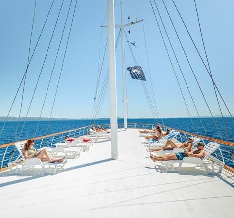 People laying on deckchairs on a boat