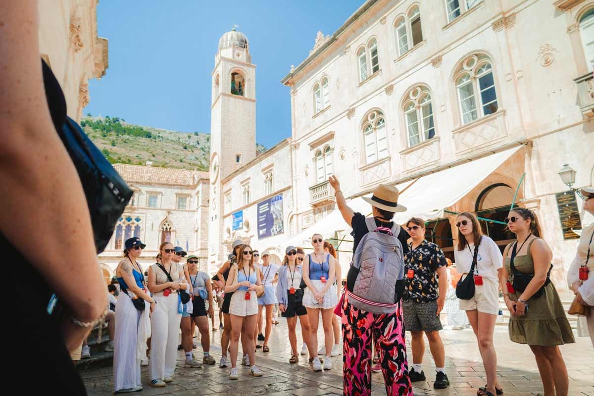 A group of people enjoying a walking Dubrovnik tour on a sunny day in Croatia.