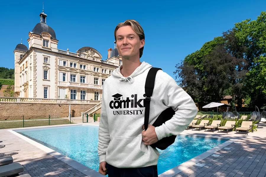 Young Man Holding Backpack Building At The Background