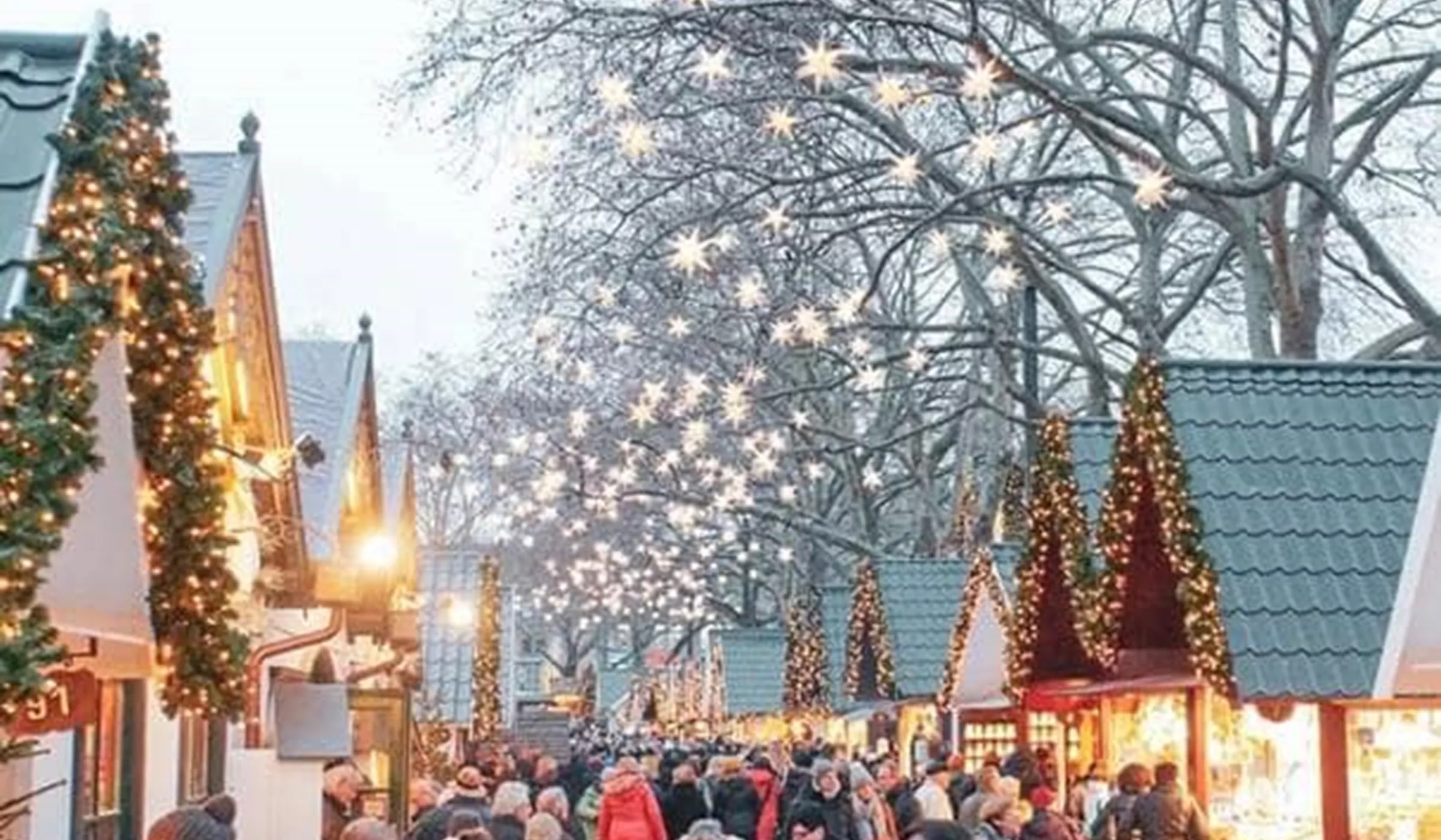 Christmas market with small stands and people walking the street