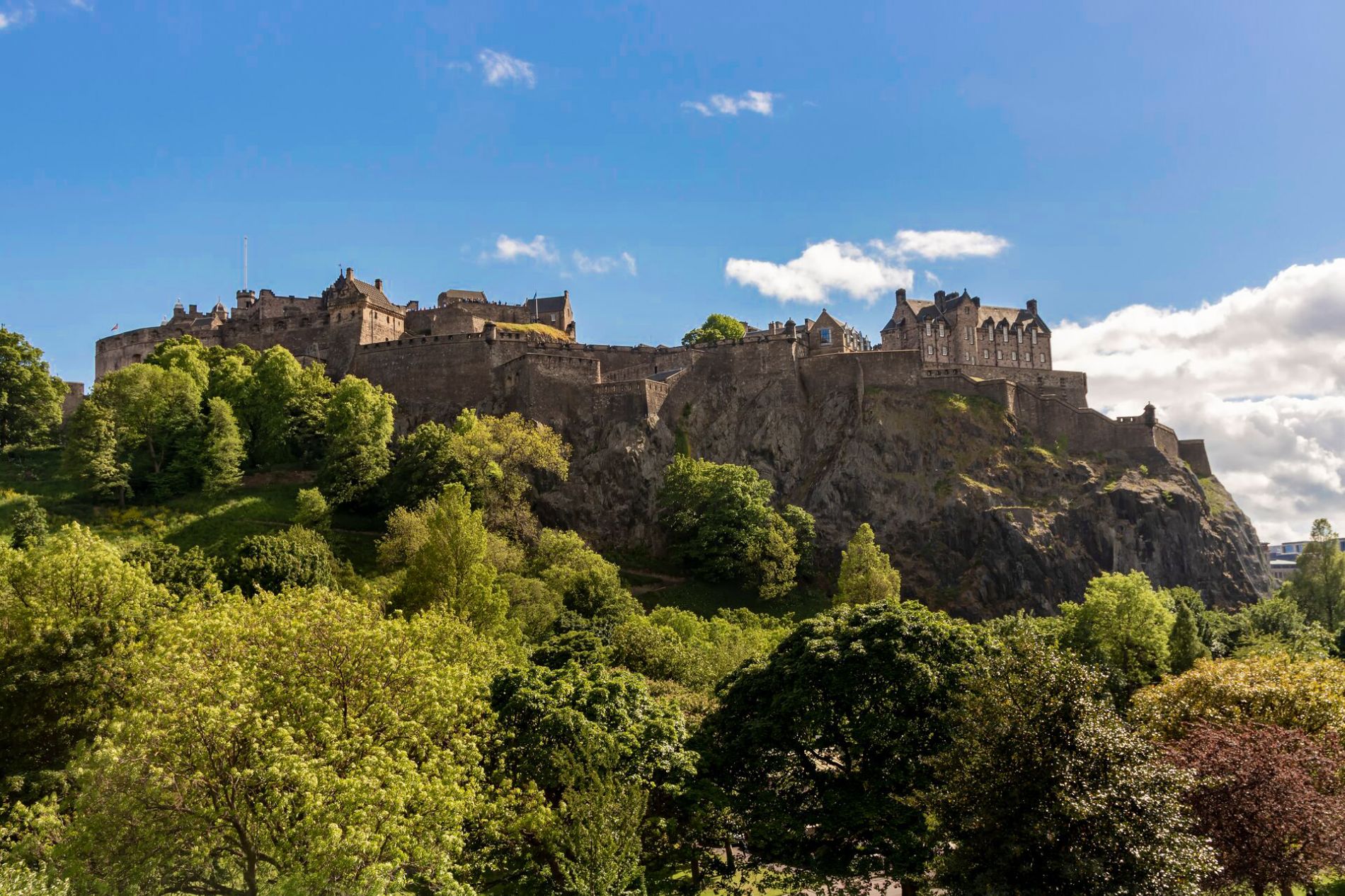 Edinburgh Castle in Scotland on a hill in summer surrounded with green trees