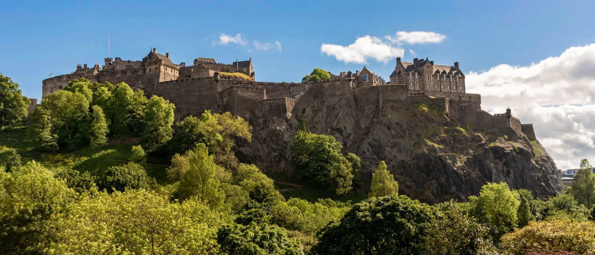 Edinburgh Castle in Scotland on a hill in summer surrounded with green trees