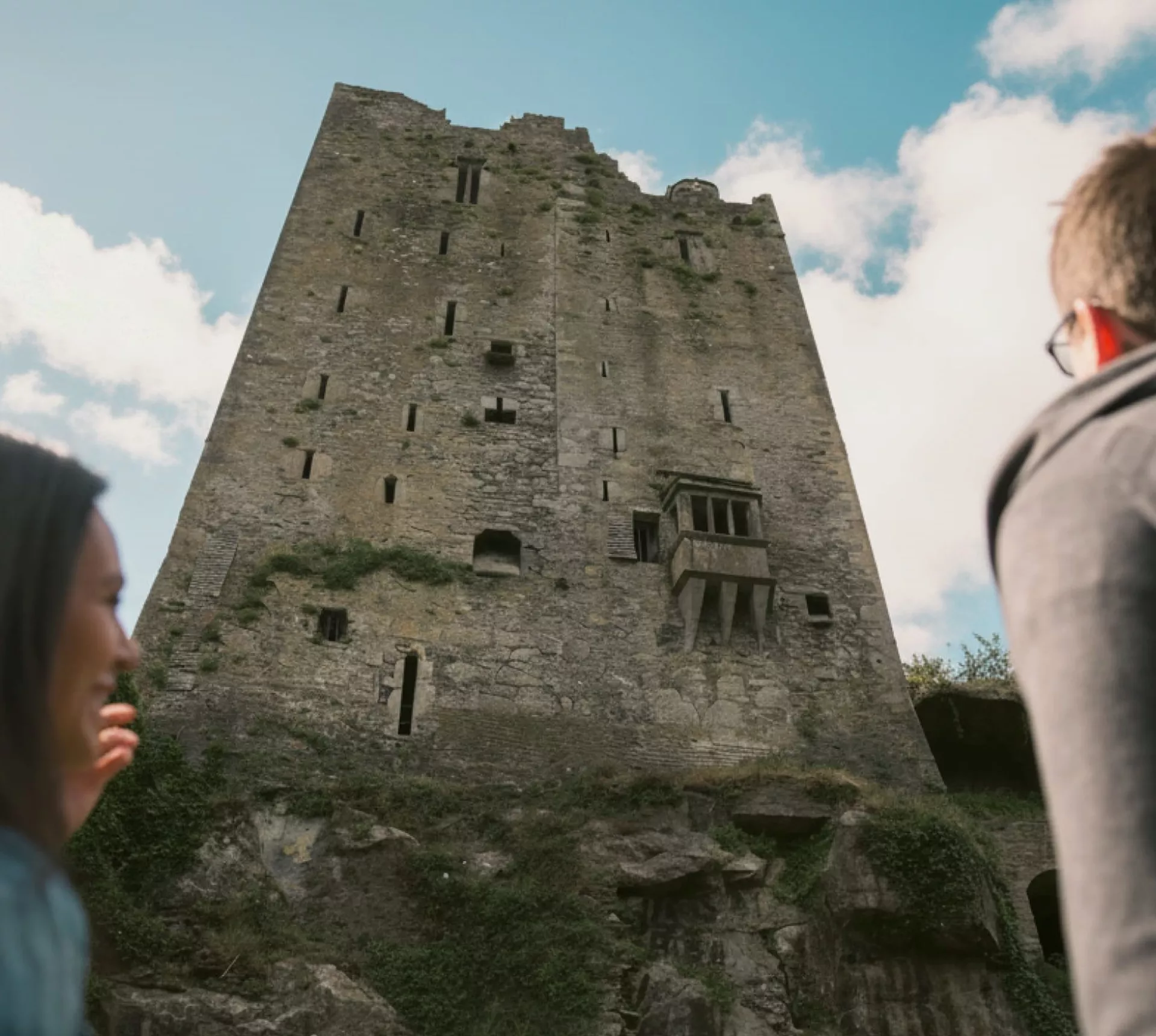 Two people look up at the historic Blarney Castle in County Cork - Contiki Ireland in a Week Tour