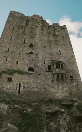 Two people look up at the historic Blarney Castle in County Cork - Contiki Ireland in a Week Tour
