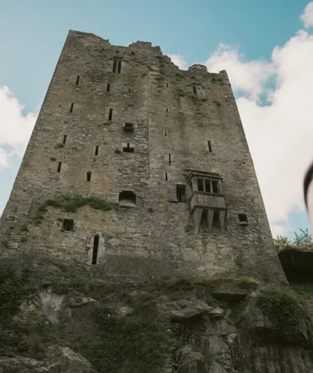 Two people look up at the historic Blarney Castle in County Cork - Contiki Ireland in a Week Tour
