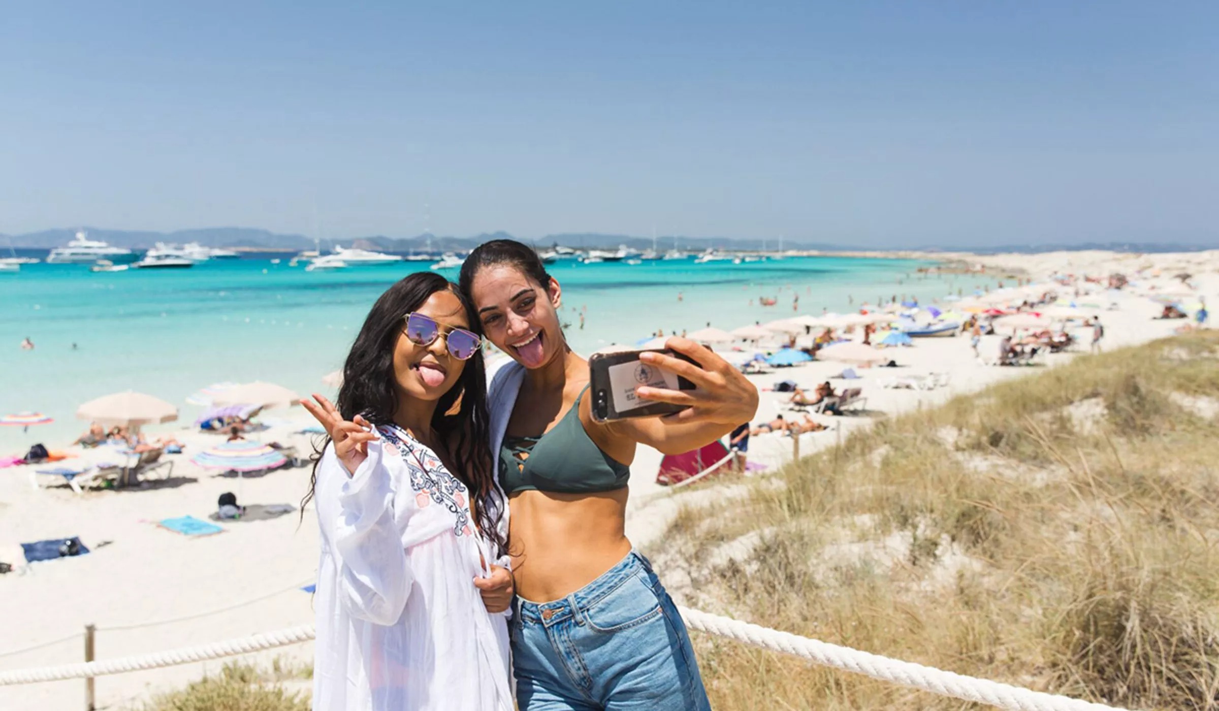 Two friends taking a selfie while enjoying a beach in Spain.