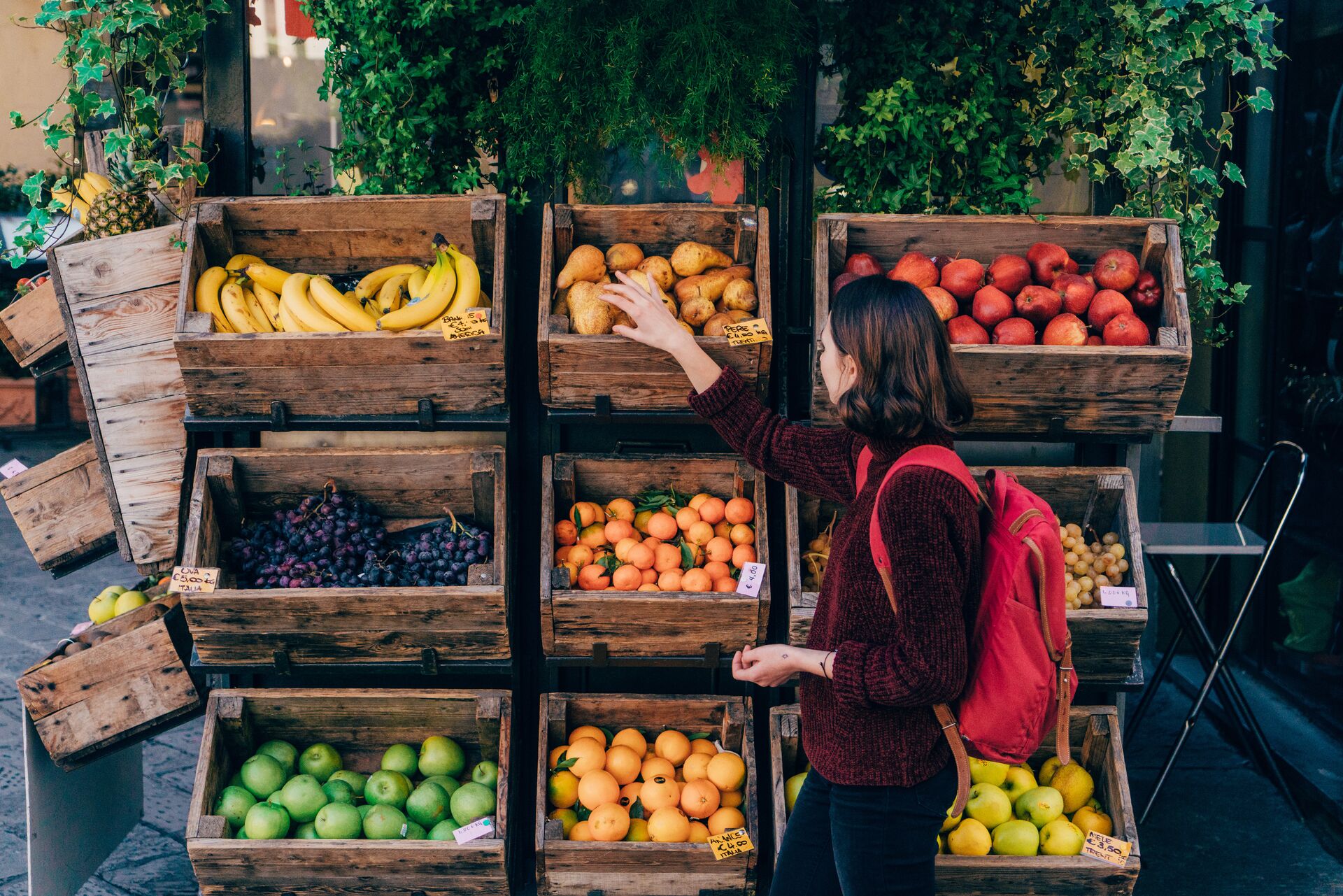 Lady picking fruit at a fruit stall