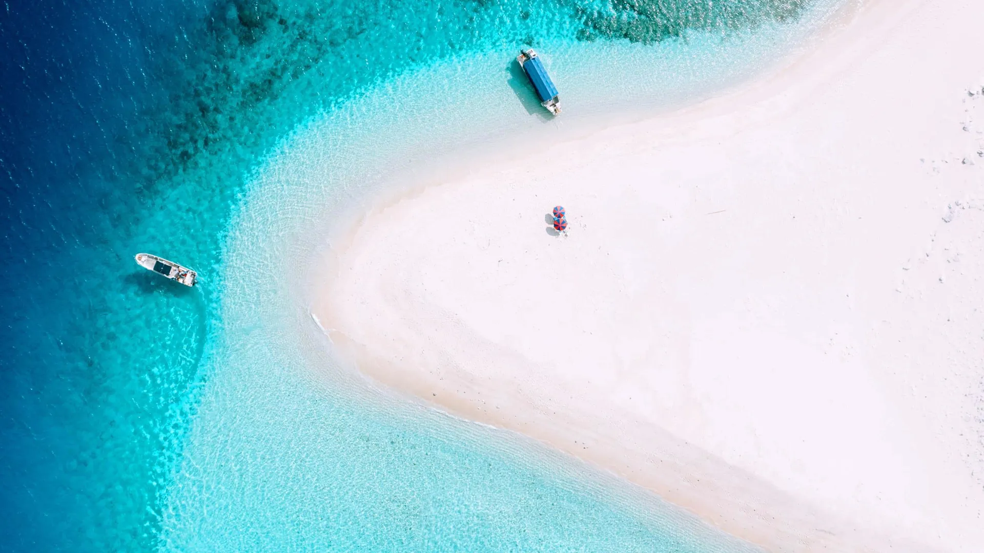 Aerial view of white sandbar, turquoise water, and two boats, Okinawa, Japan