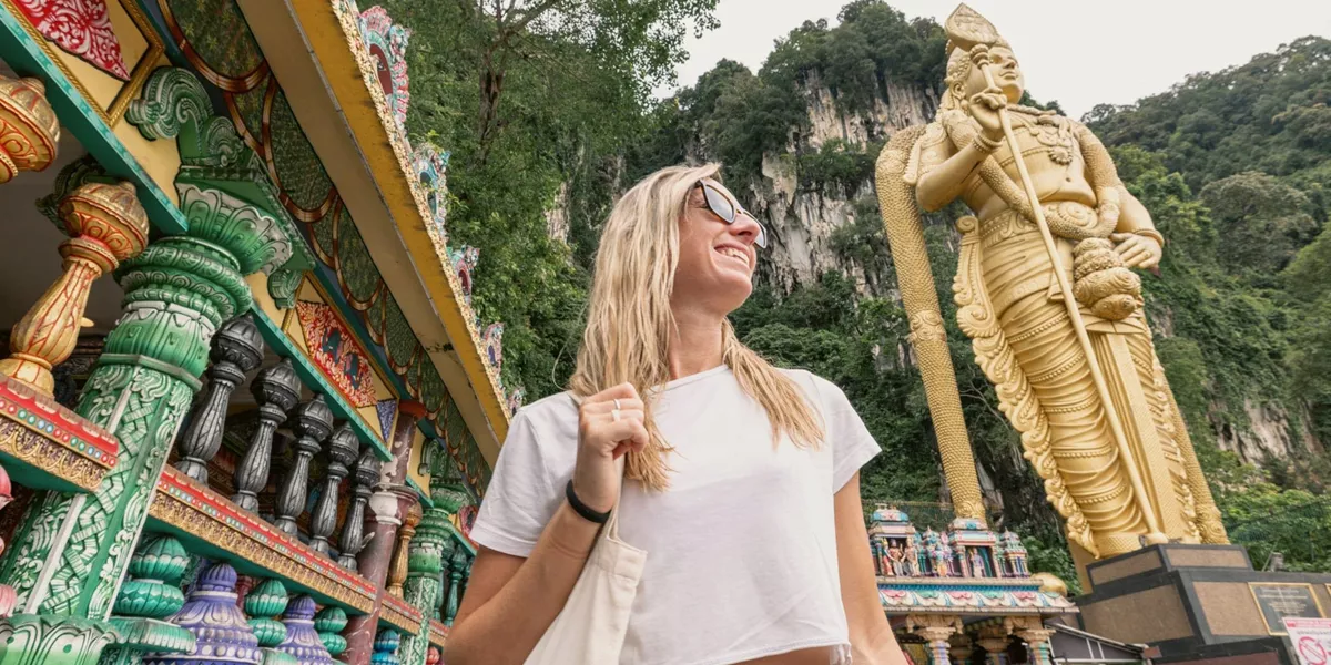 Traveller explores Batu Caves and the golden Lord Murugan statue on the Contiki Thailand, Malaysia & Singapore Tour