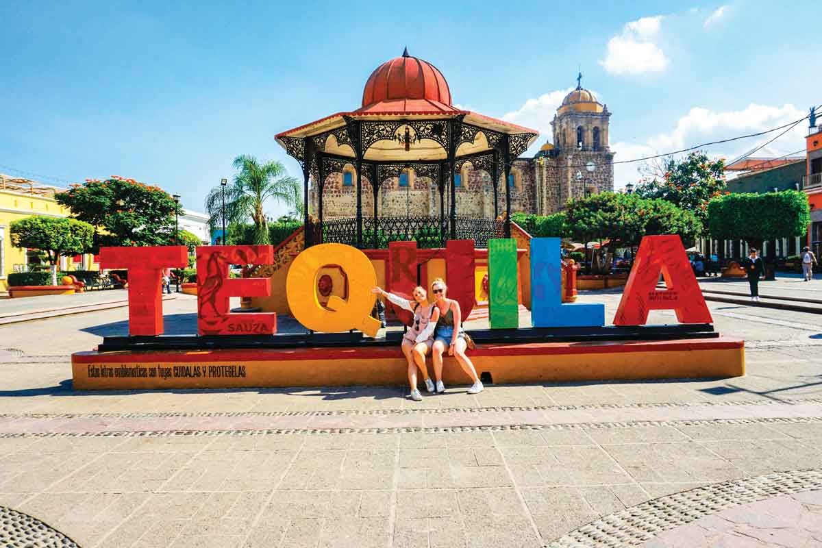 Two Friends In Front Of Tequila Sign In Mexico