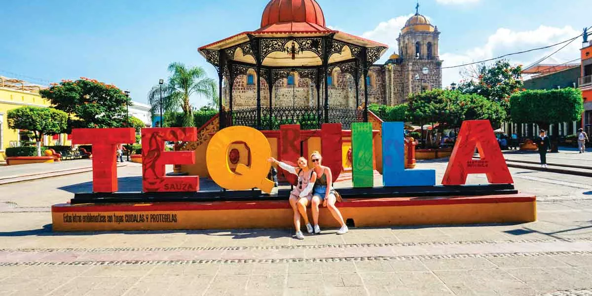 Two Friends In Front Of Tequila Sign In Mexico