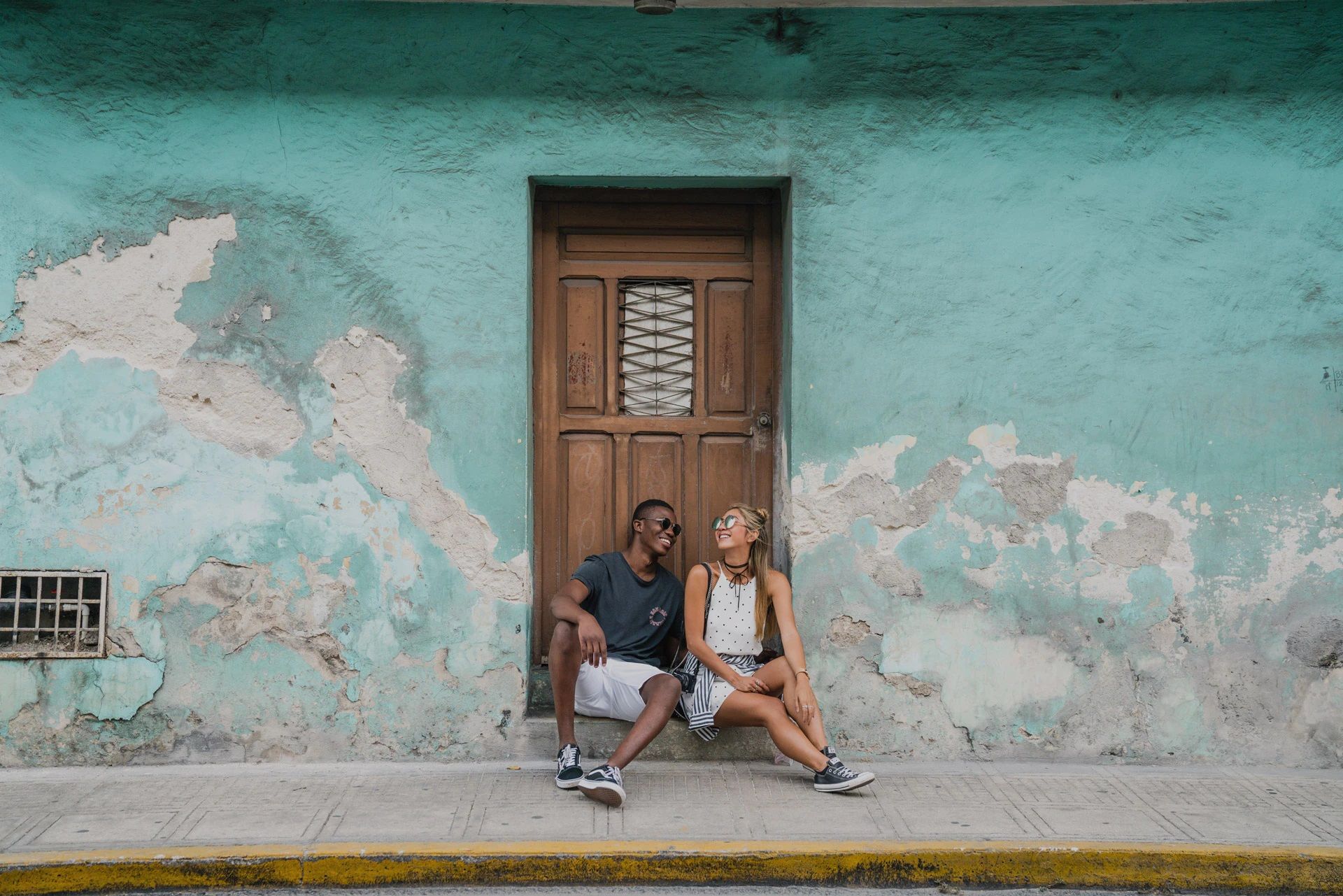 Couple sitting at the door to an old building