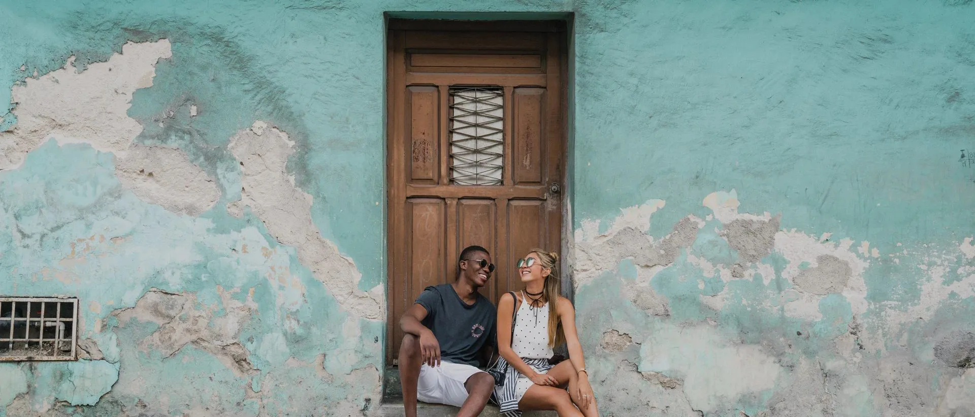 Couple sitting at the door to an old building