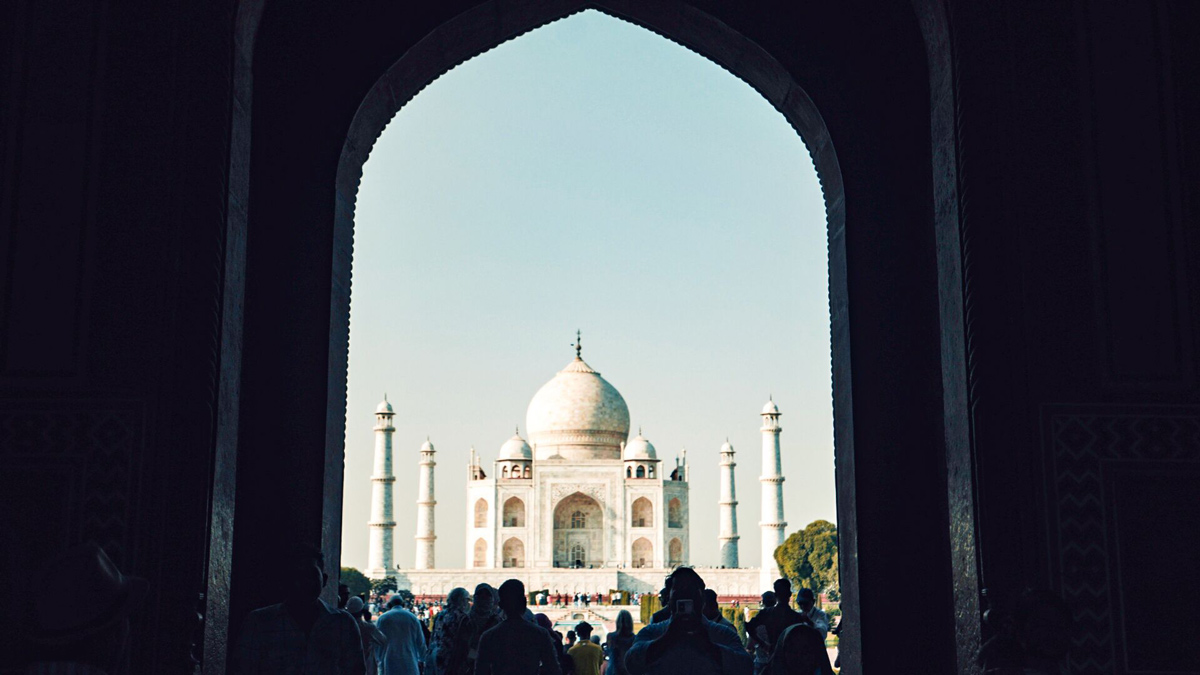 View Of India Landmark From A Large Gate People Walking Towards It