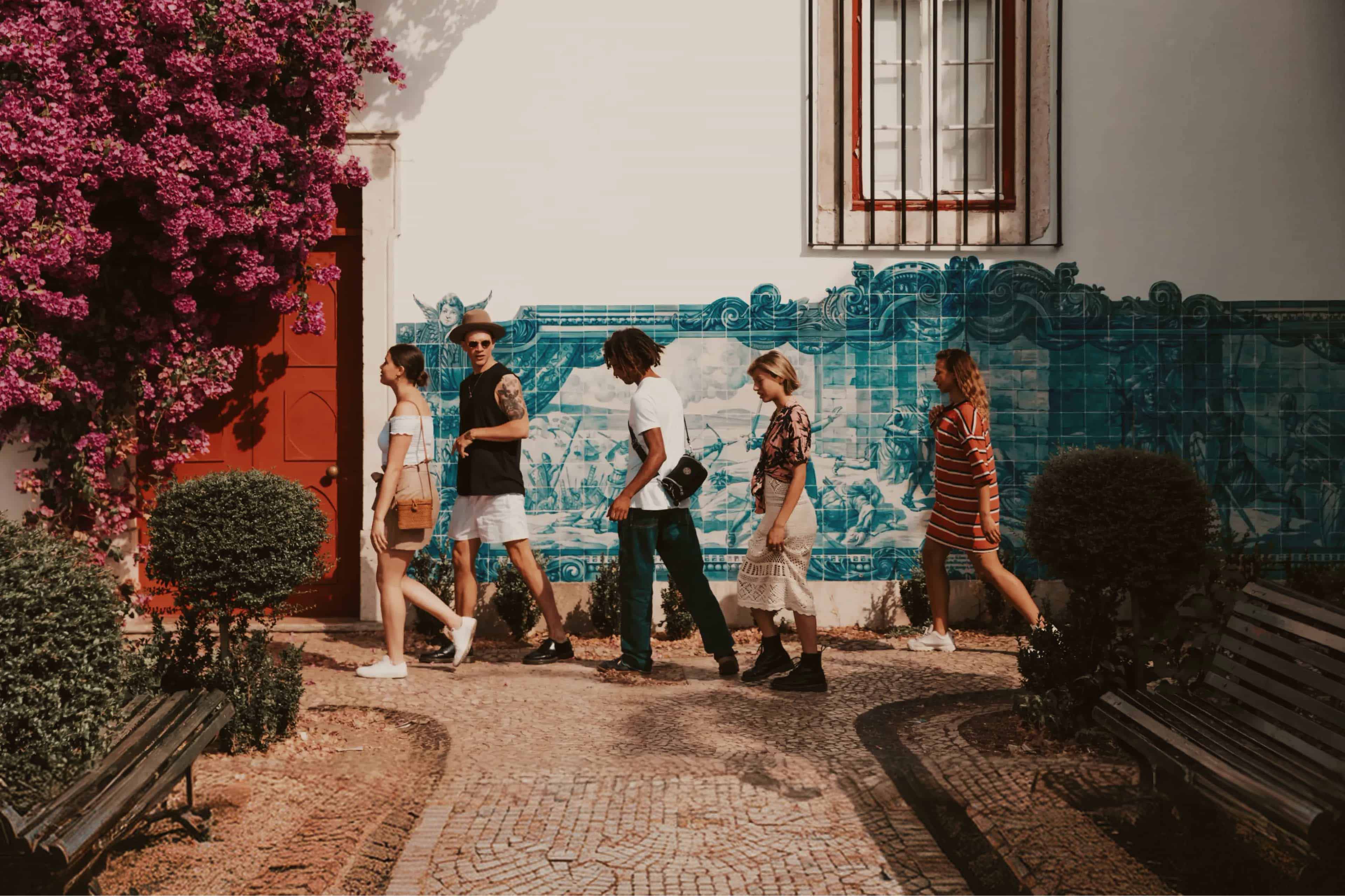 travellers-walking-past-a-wall-of-traditional-blue-azulejo-tiles-in-a-garden-courtyard-portugal.jpg
