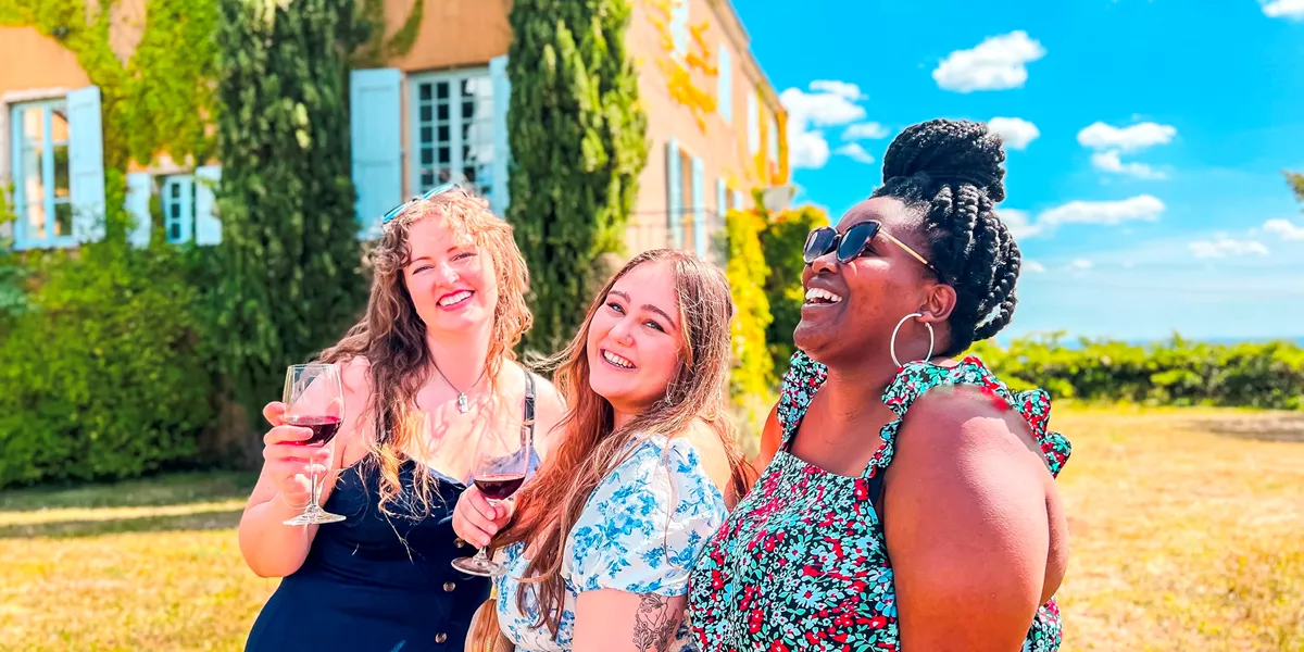 Travellers enjoying a glass in of wine in the Chateau gardens. Beaujolais Wine Region, France