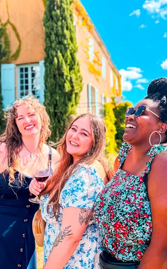 Travellers enjoying a glass in of wine in the Chateau gardens. Beaujolais Wine Region, France