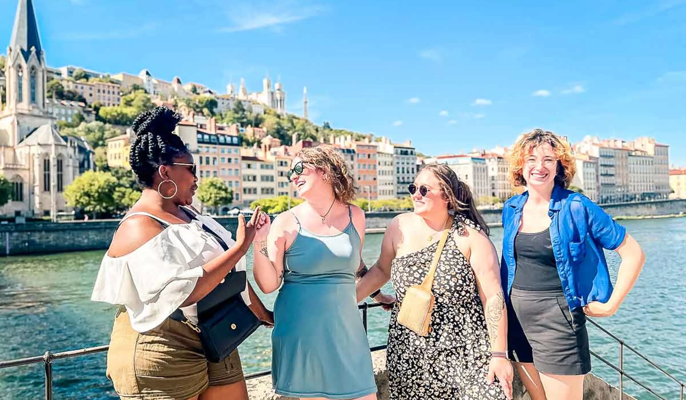 Four Young Female Travelers Laughing In The Sun