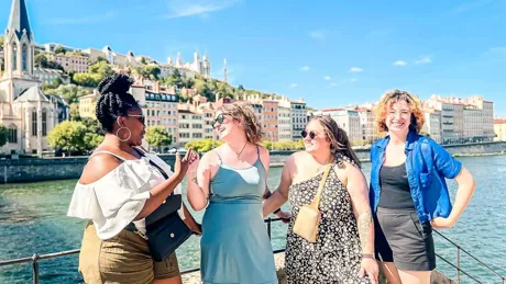 Four Young Female Travelers Laughing In The Sun