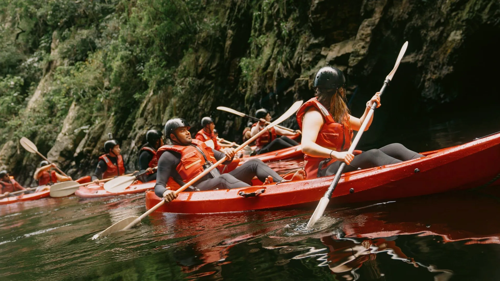 Travellers kayaking through the river on Contiki's Garden Route & Addo Tour in South Africa