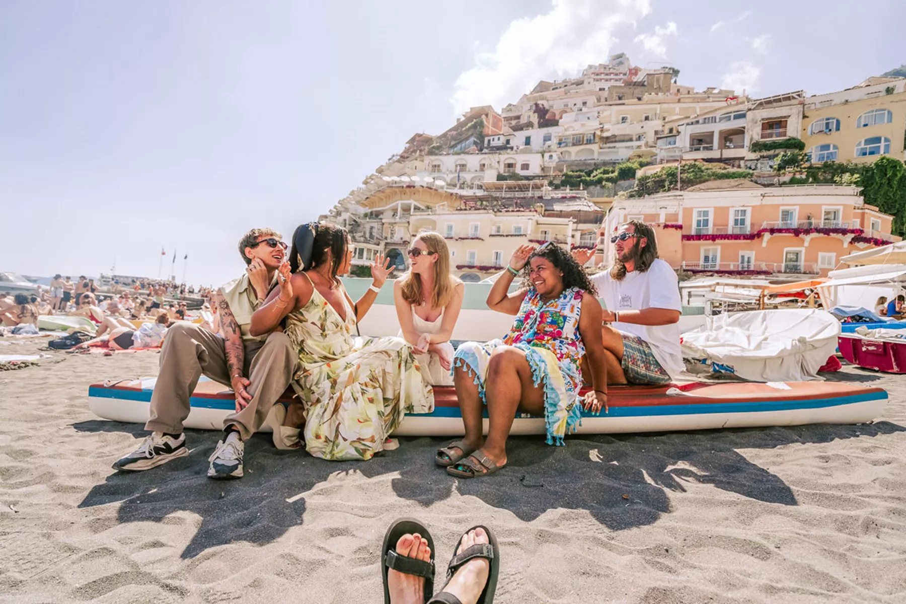 Friends enjoying a sunny day at the beach of Amalfi Coast in Italy