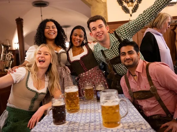 Friends enjoying beer and smiling in Germany.