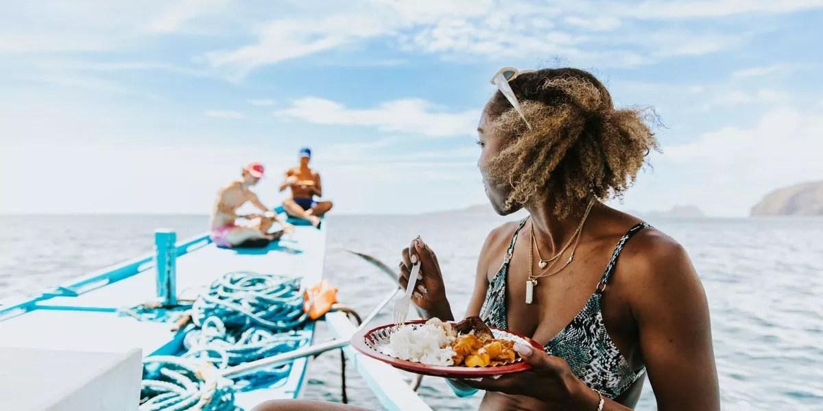 Woman eating on a boat in the Philippines.