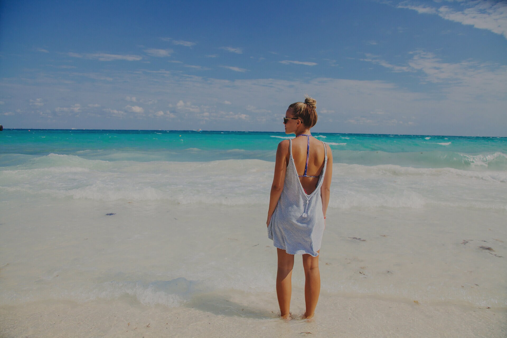 Woman in a blue dress standing on beach in Cancun, Mexico