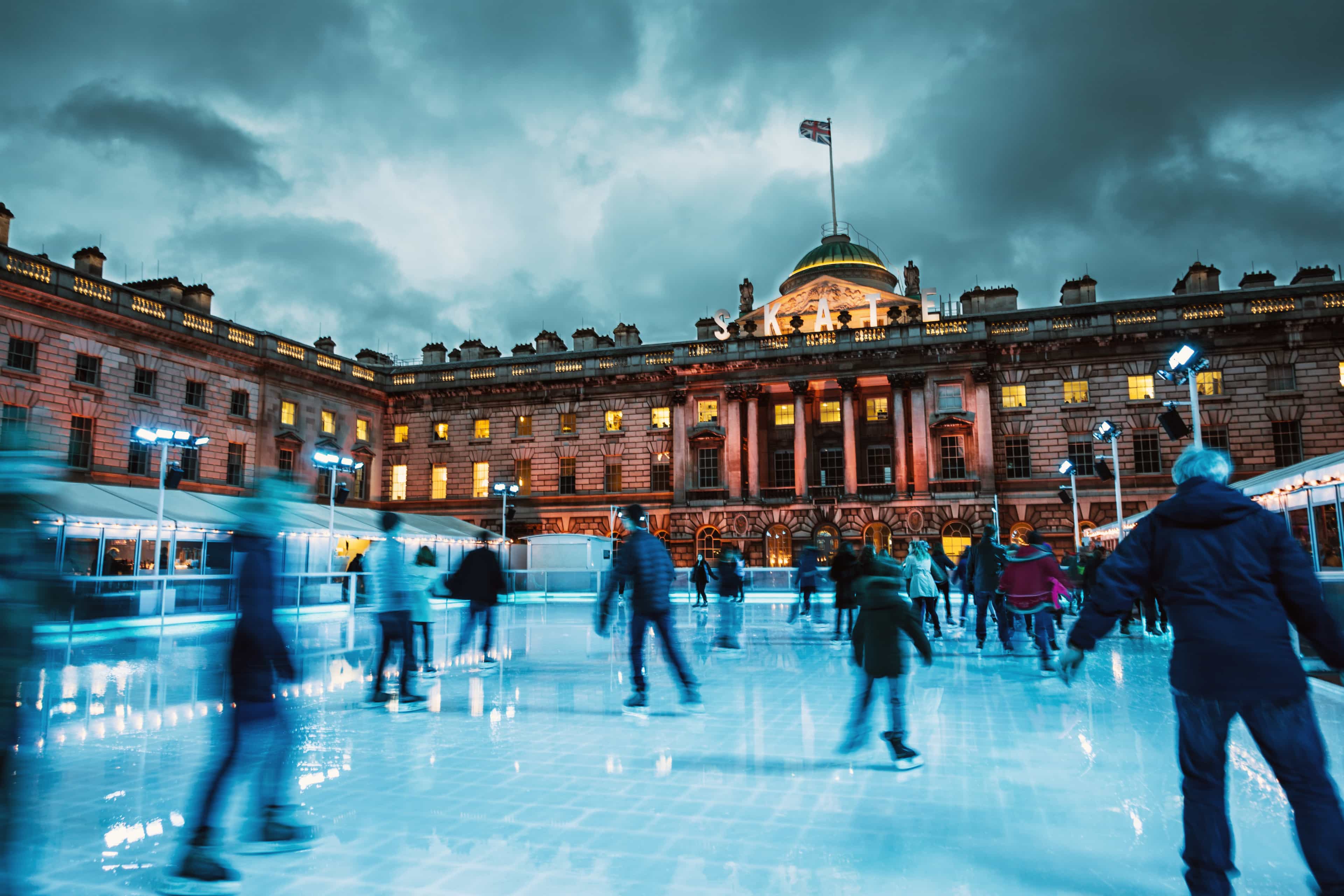 Ice skaters gliding across an outdoor rink at Somerset House, London, England