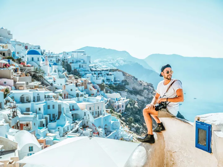 Man On Greek Rooftops With Camera In Santorini