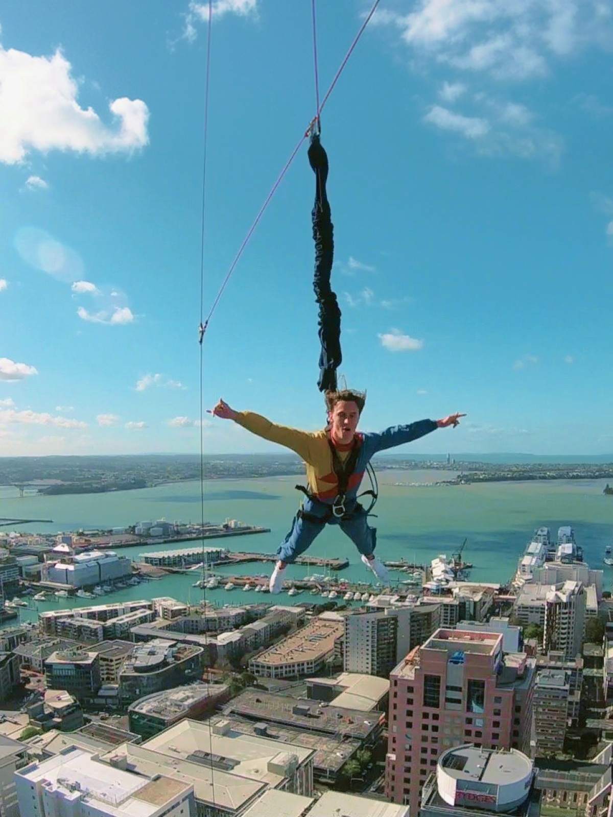 Traveller bungee jumping from Auckland Harbour Bridge above Waitematā Harbour, Auckland, New Zealand.