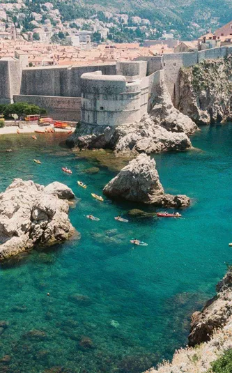 Crystal-clear turquoise waters meet the medieval walls of Dubrovnik on the Contiki Best of Balkans Tour