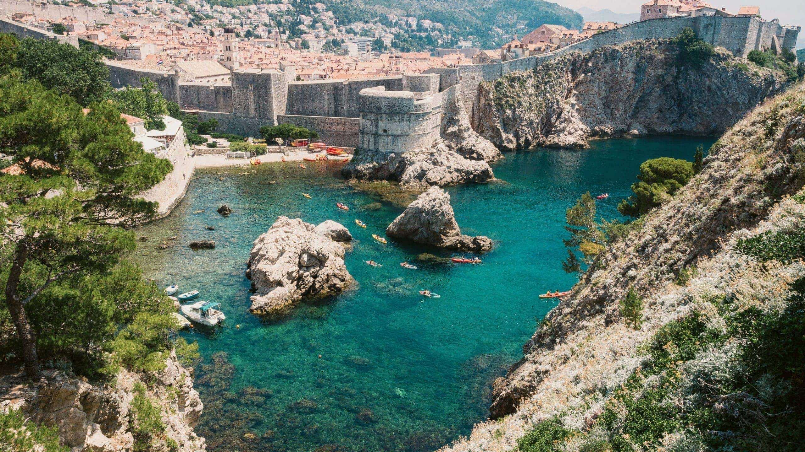 Crystal-clear turquoise waters meet the medieval walls of Dubrovnik on the Contiki Best of Balkans Tour