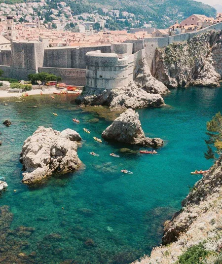 Crystal-clear turquoise waters meet the medieval walls of Dubrovnik on the Contiki Best of Balkans Tour