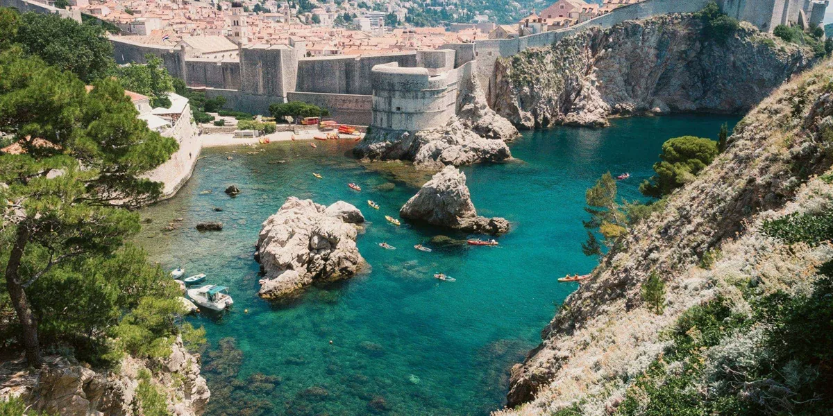 Crystal-clear turquoise waters meet the medieval walls of Dubrovnik on the Contiki Best of Balkans Tour