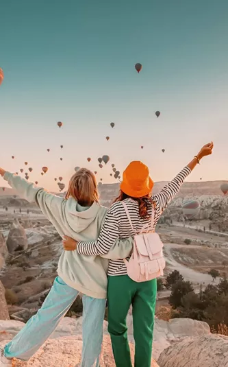 Travellers watch hot air balloons rise over Cappadocia at sunrise on the Contiki Best of Turkey Tour